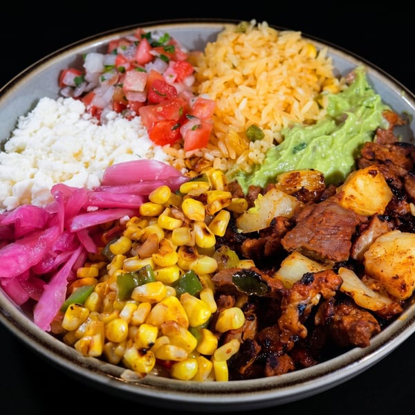 Colorful platter with grilled meat and vegetables, yellow rice, white rice, guacamole, corn, pickled onions, and tomato salsa.